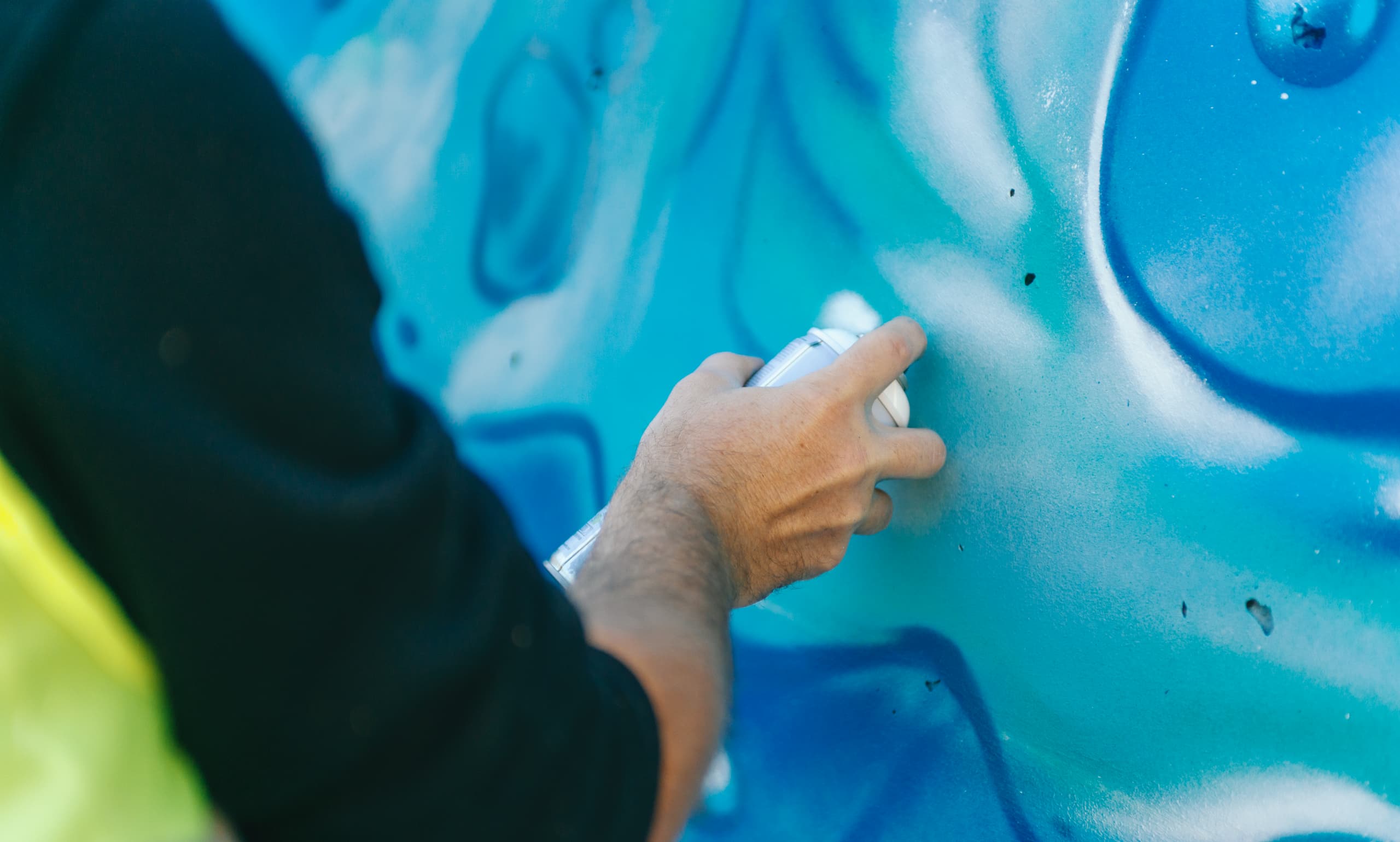 Artiste travaillant sur la fresque sous l'autoroute A480 à Grenoble