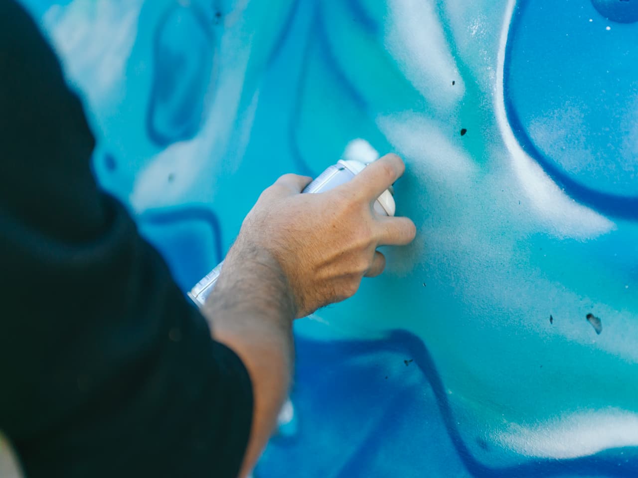Artiste travaillant sur la fresque sous l'autoroute A480 à Grenoble