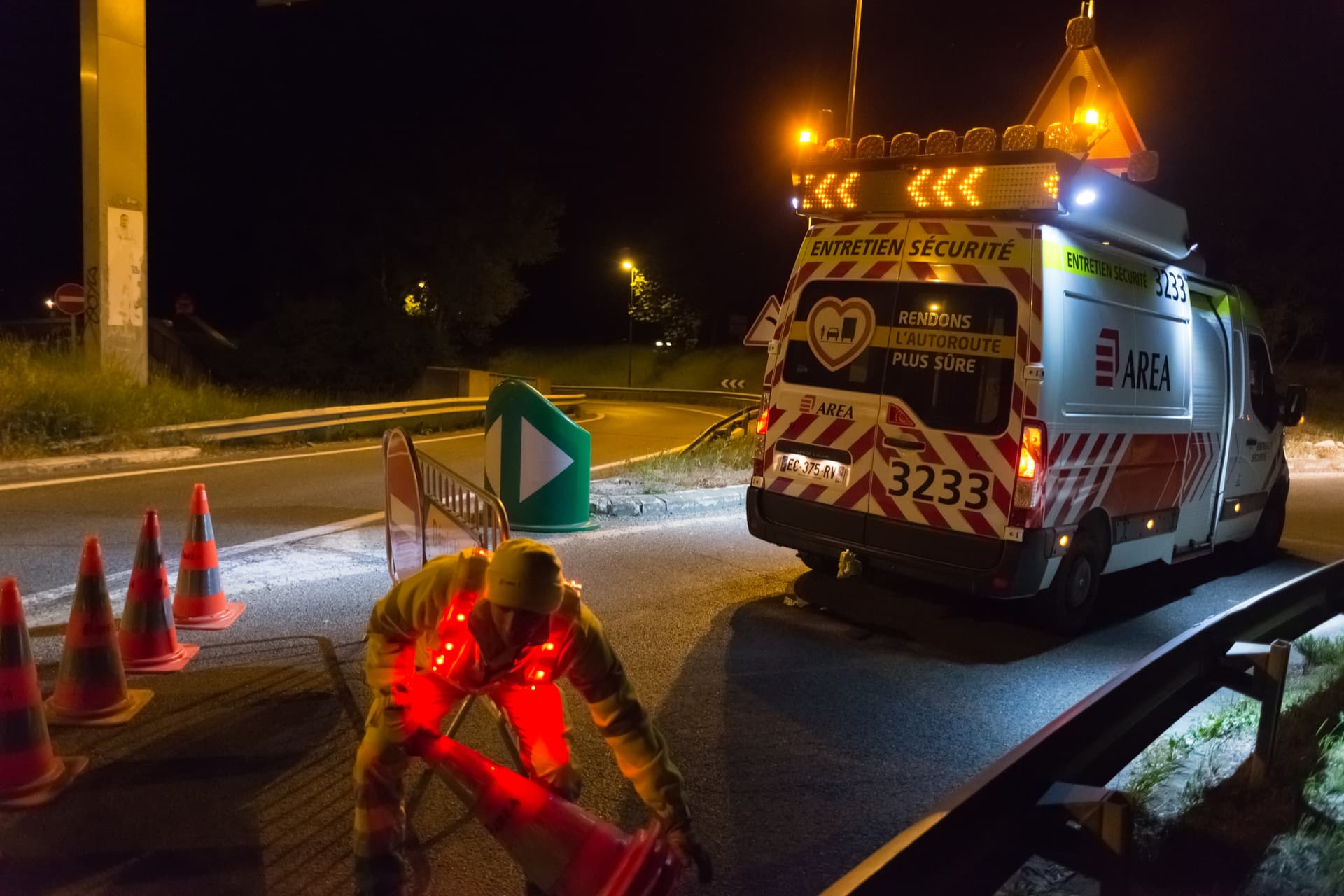 Agent d'AREA installant de nuit une signalisation de travaux
